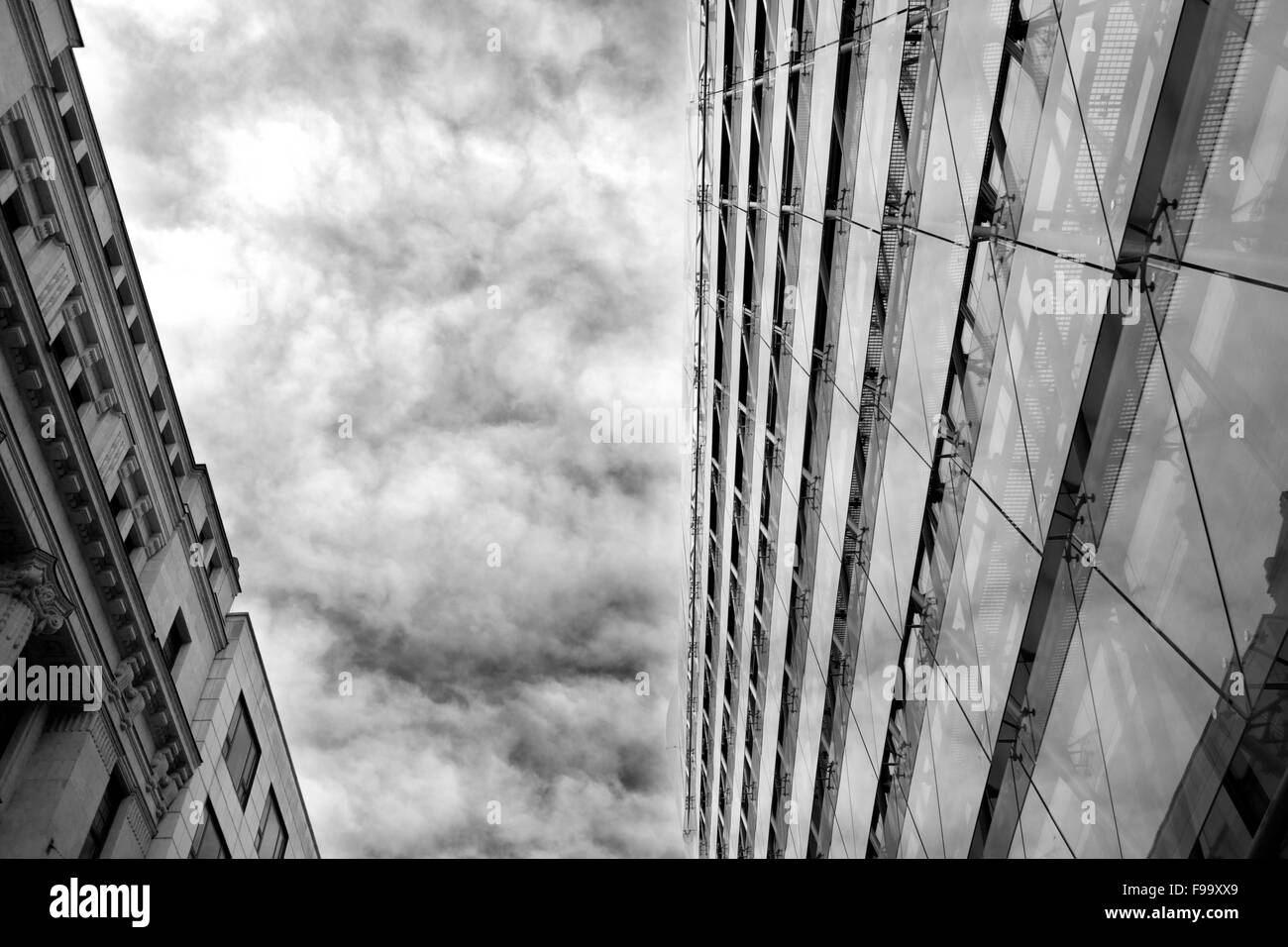 Édifice moderne en verre en face de l'ancienne, séparés par un ciel nuageux Banque D'Images