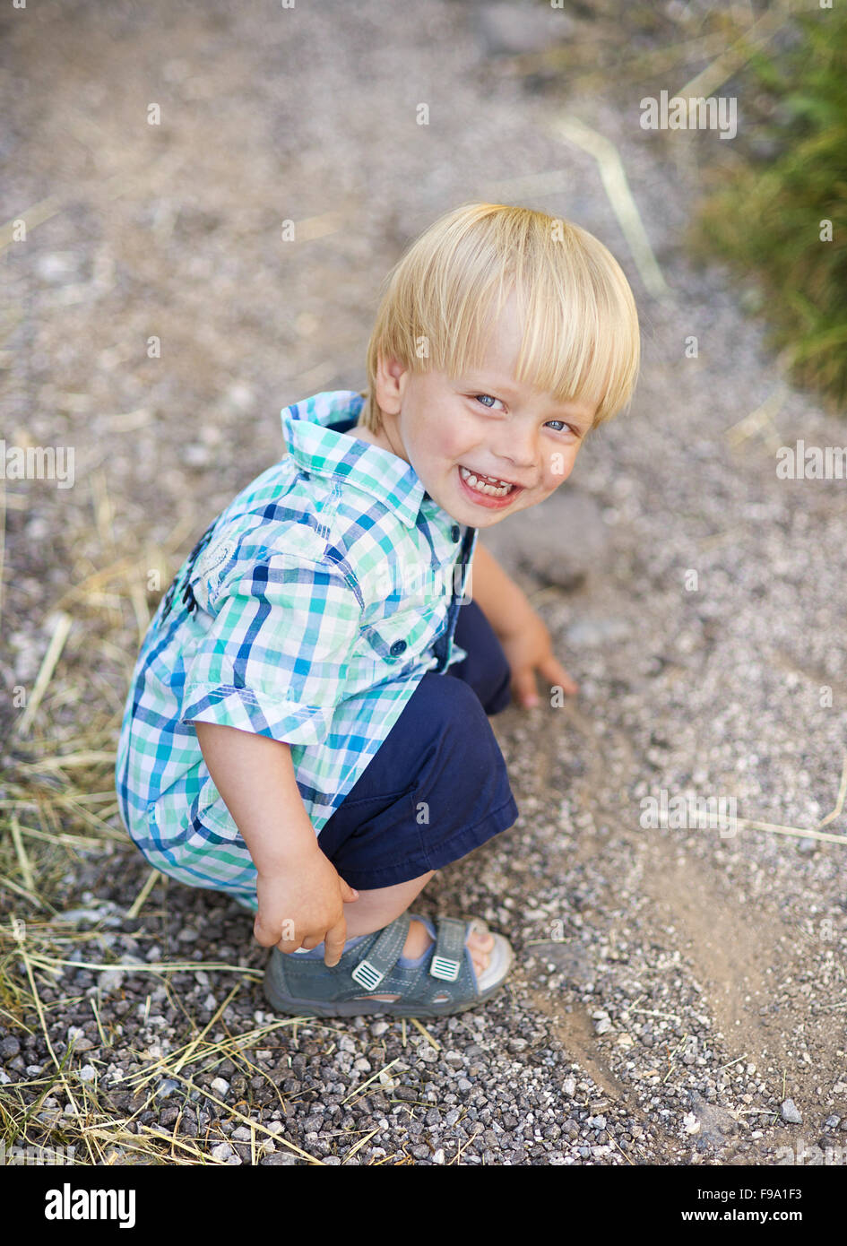 Portrait de petit garçon blond posant dehors Banque D'Images