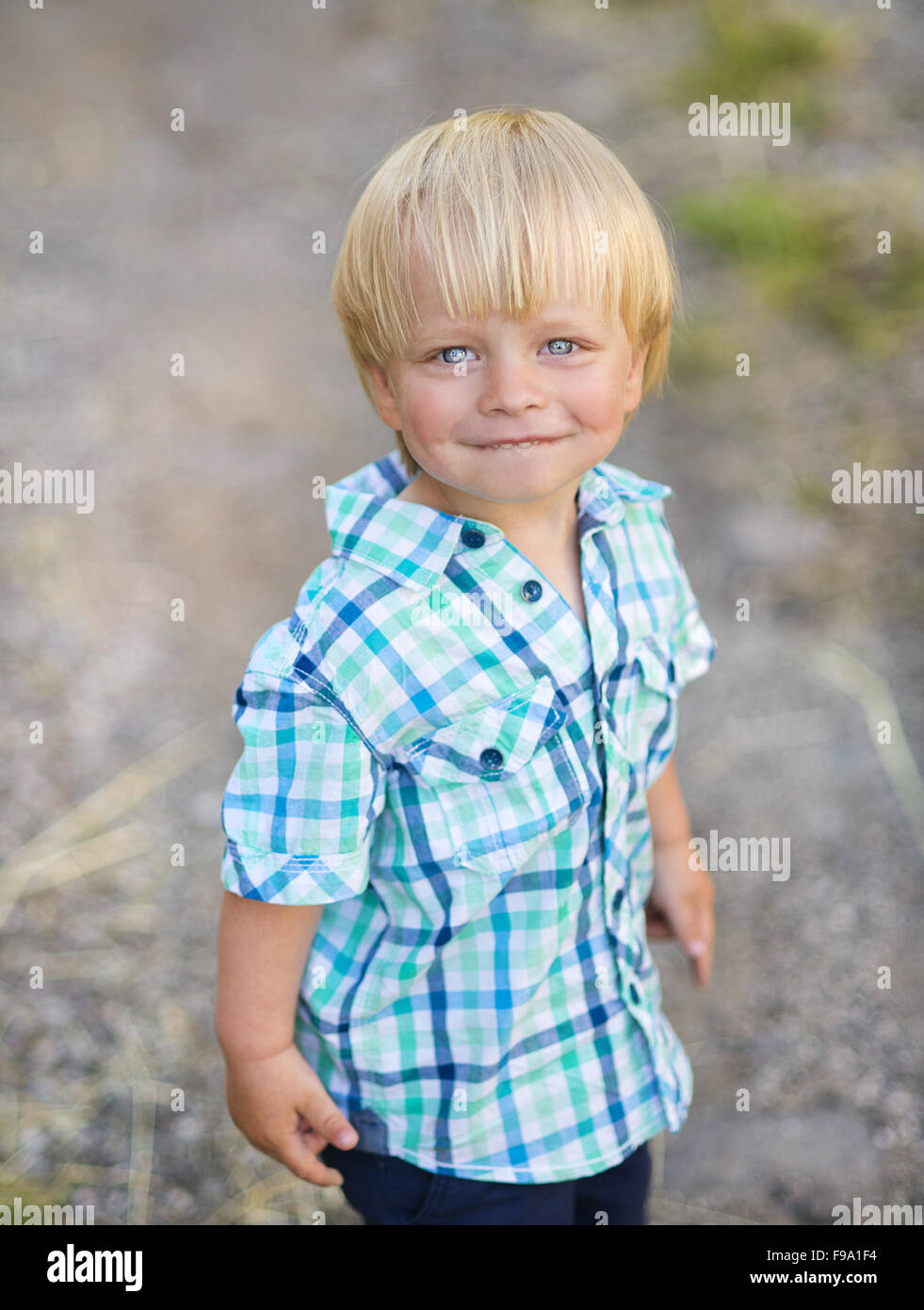 Portrait de petit garçon blond posant dehors Banque D'Images