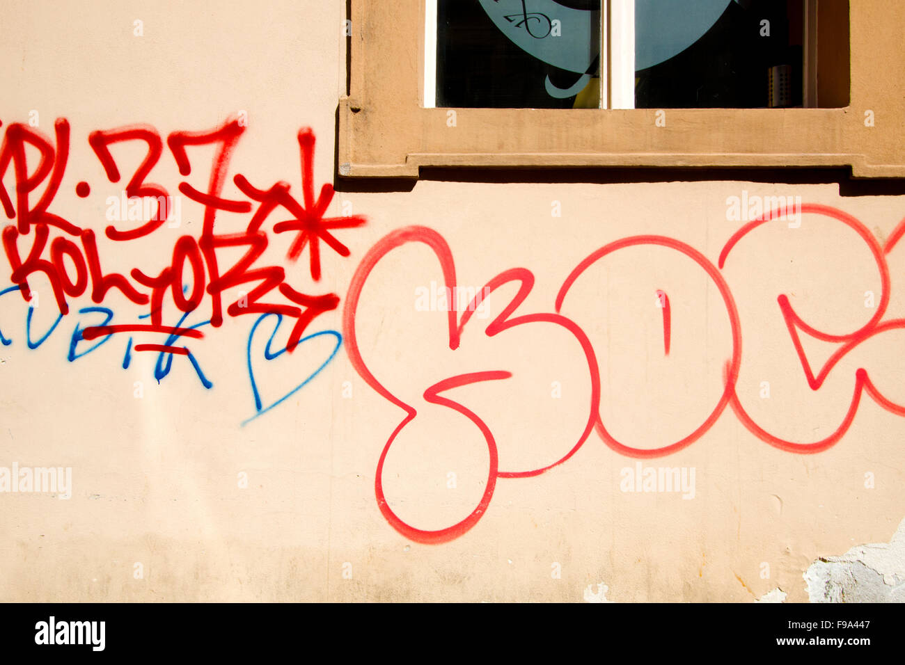 Graffiti rouge sur un mur avec une fenêtre Banque D'Images