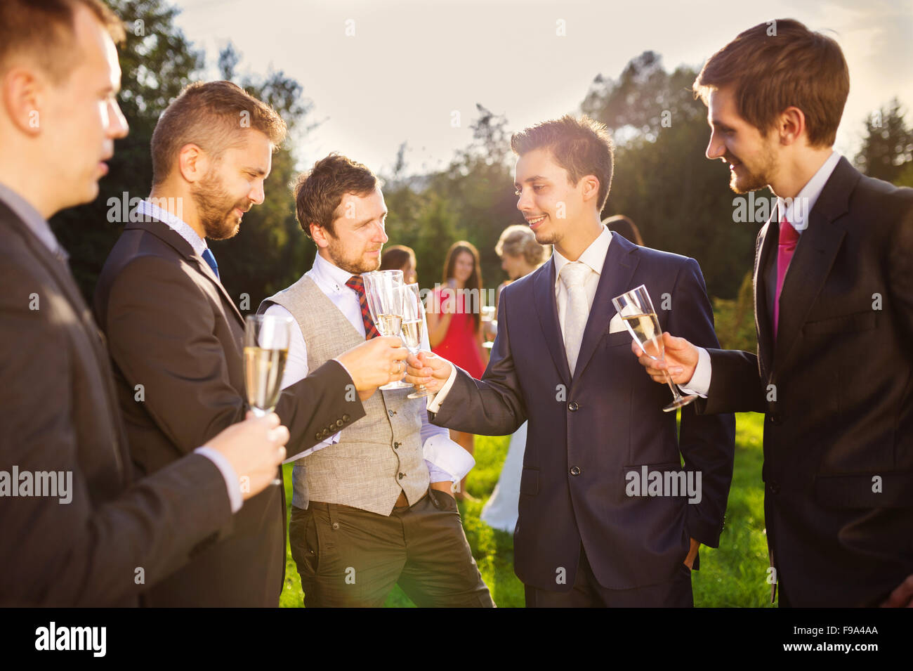 Marié avec quatre garçons heureux le brunissage à la réception de mariage à l'extérieur Banque D'Images