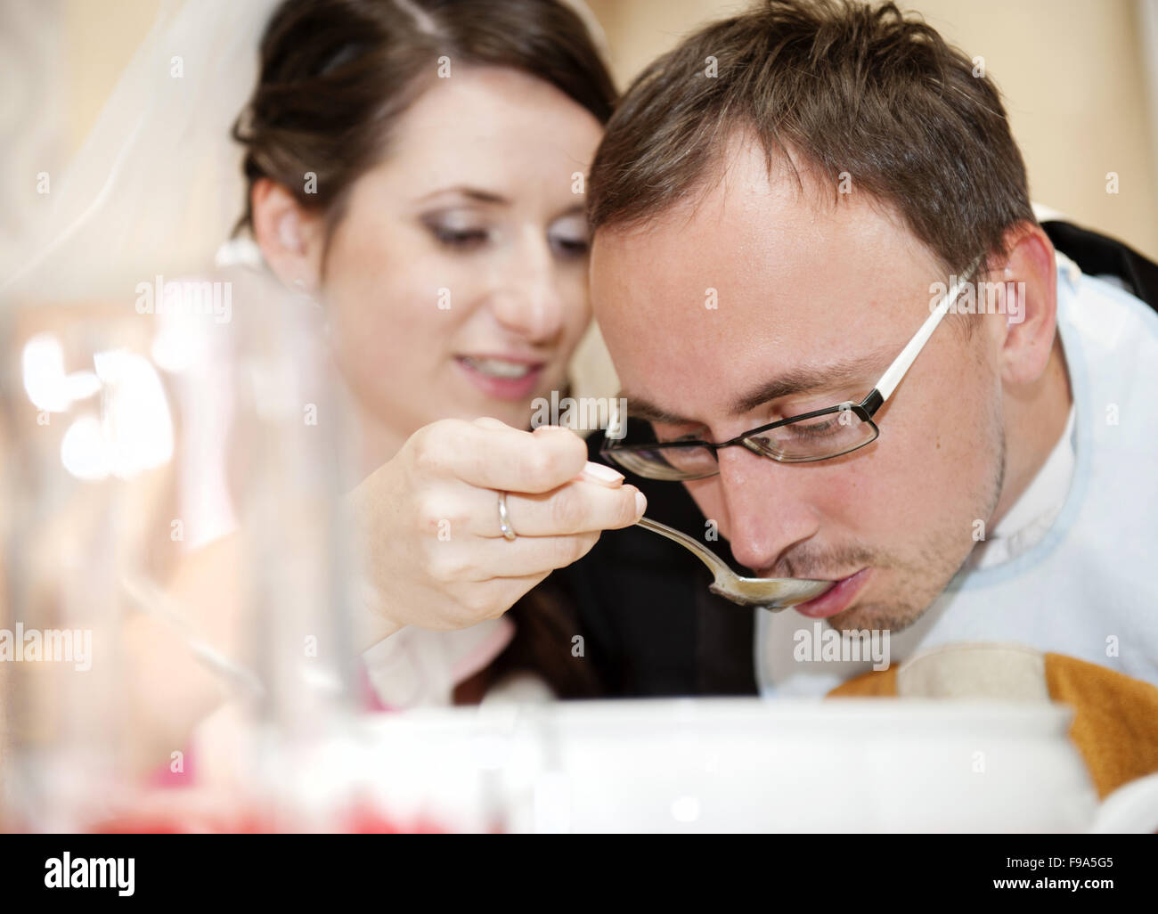 Jeunes mariés mangent à la réception de mariage Banque D'Images