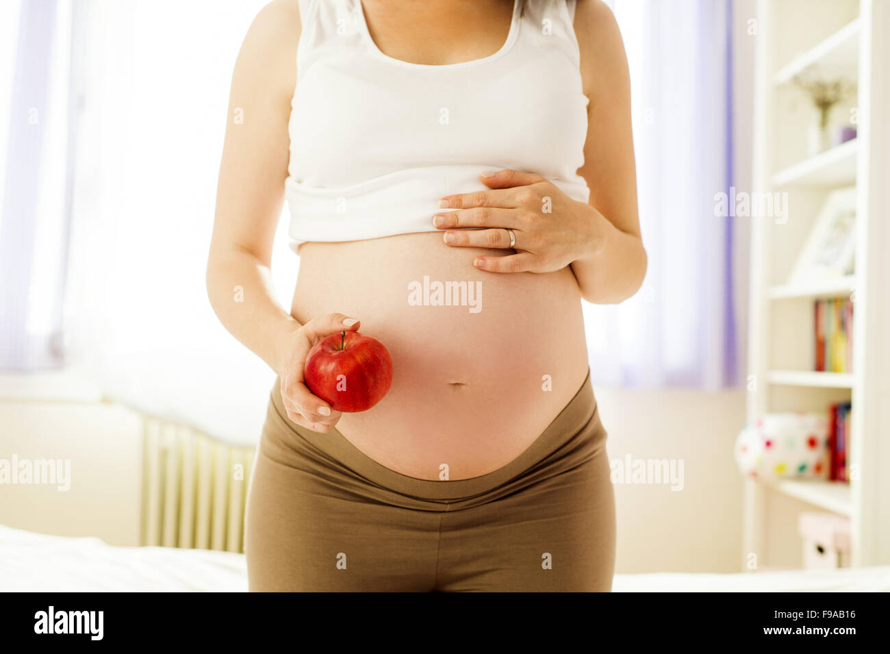 Portrait de femme enceinte méconnaissable d'une pomme dans sa main Banque D'Images