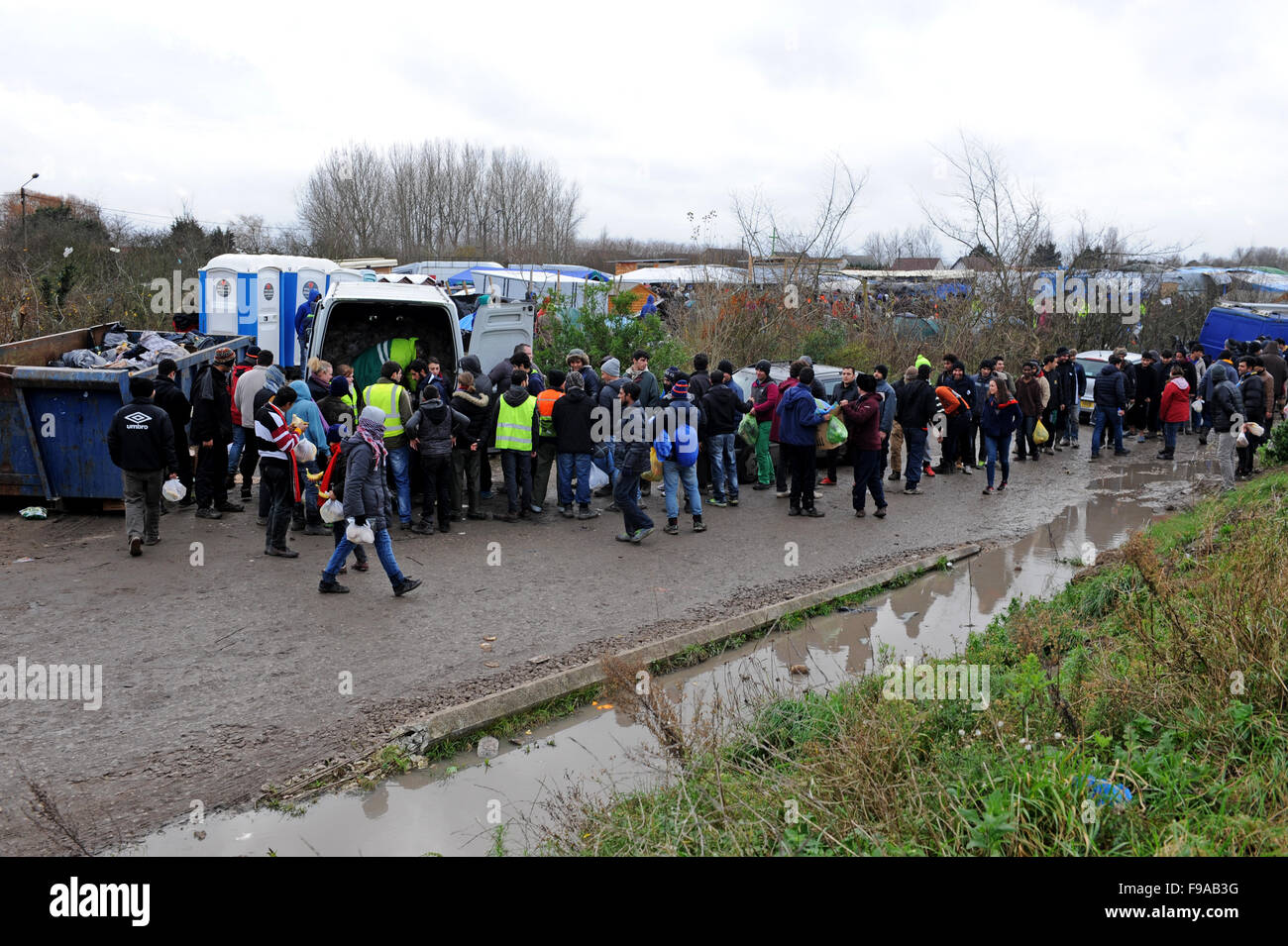 Jungle, Calais, France. File d'attente pour les réfugiés des colis qui sont distribués à partir d'un van, près de l'ouverture du camp. Banque D'Images