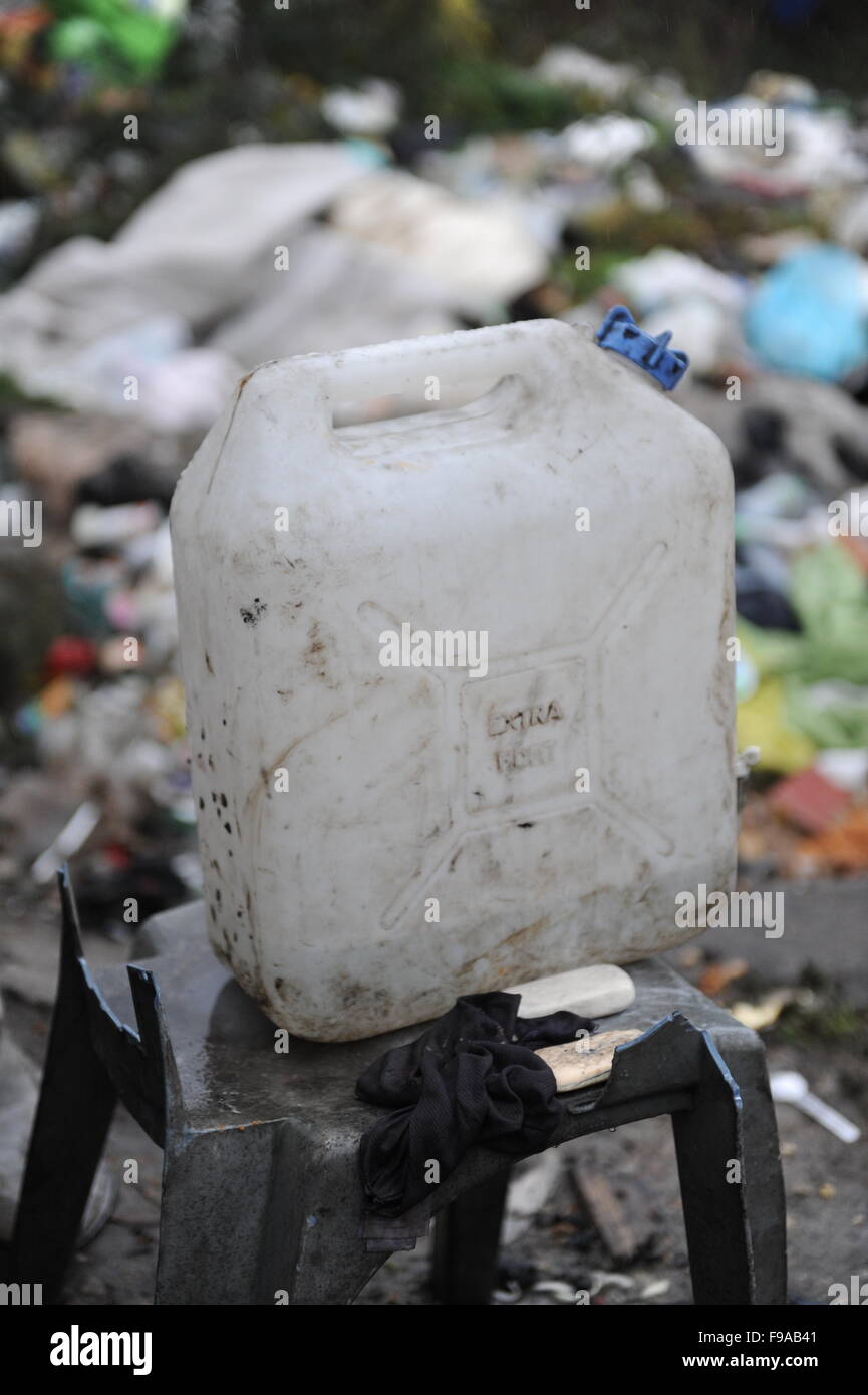 Jungle, Calais, France. Un seul récipient en plastique 3,78 l d'eau sale se dresse au milieu de la poubelle du camp. Un groupe de réfugiés utilisez cette pour recueillir de l'eau pour boire, se laver et cuisiner. Banque D'Images