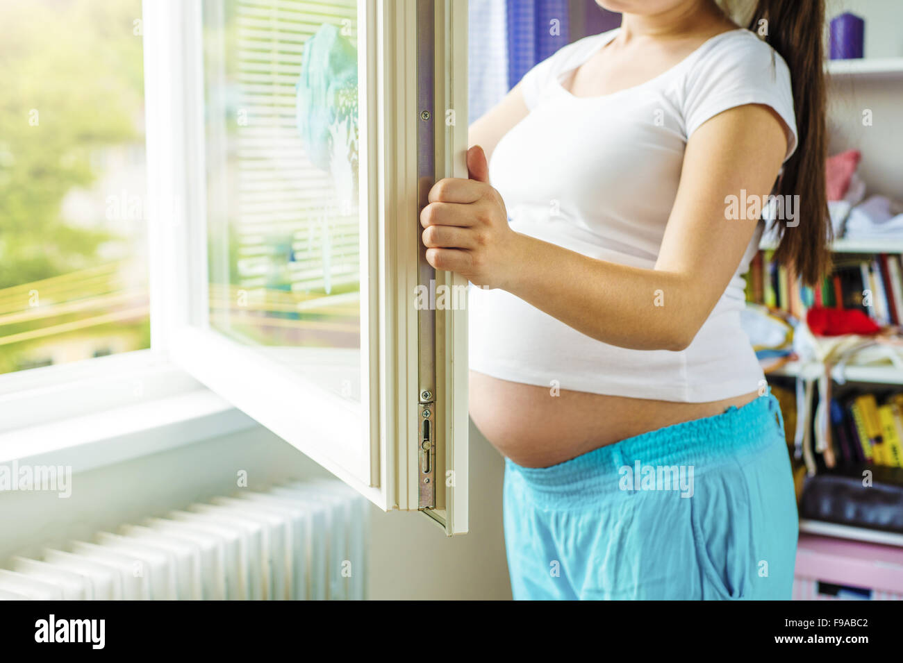 Portrait de femme enceinte méconnaissable nettoyage windows Banque D'Images