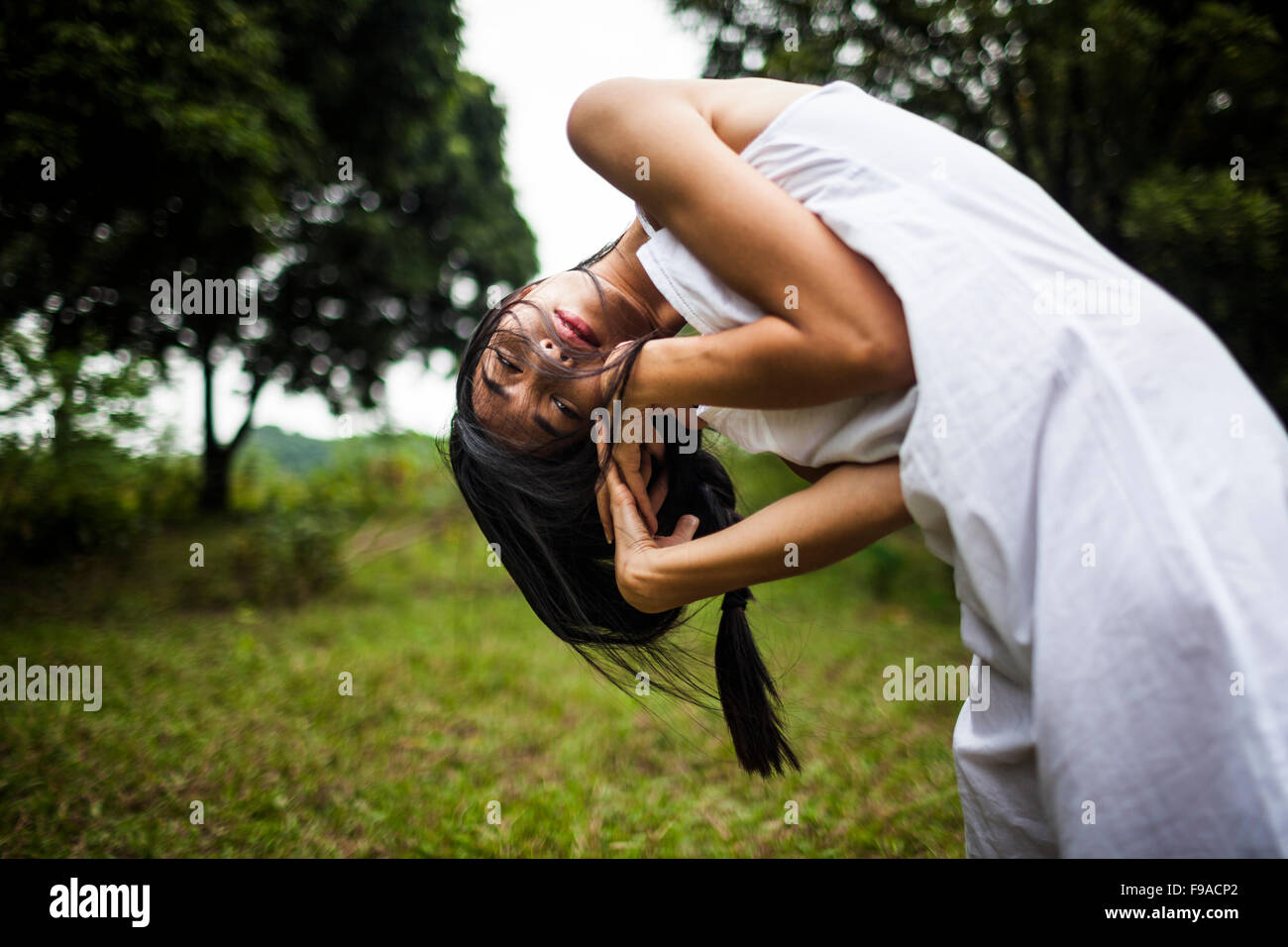 Une jeune vietnamienne portant tous les vêtements blancs au milieu d'un champ vert dans les régions rurales de Hanoi, Vietnam. Banque D'Images