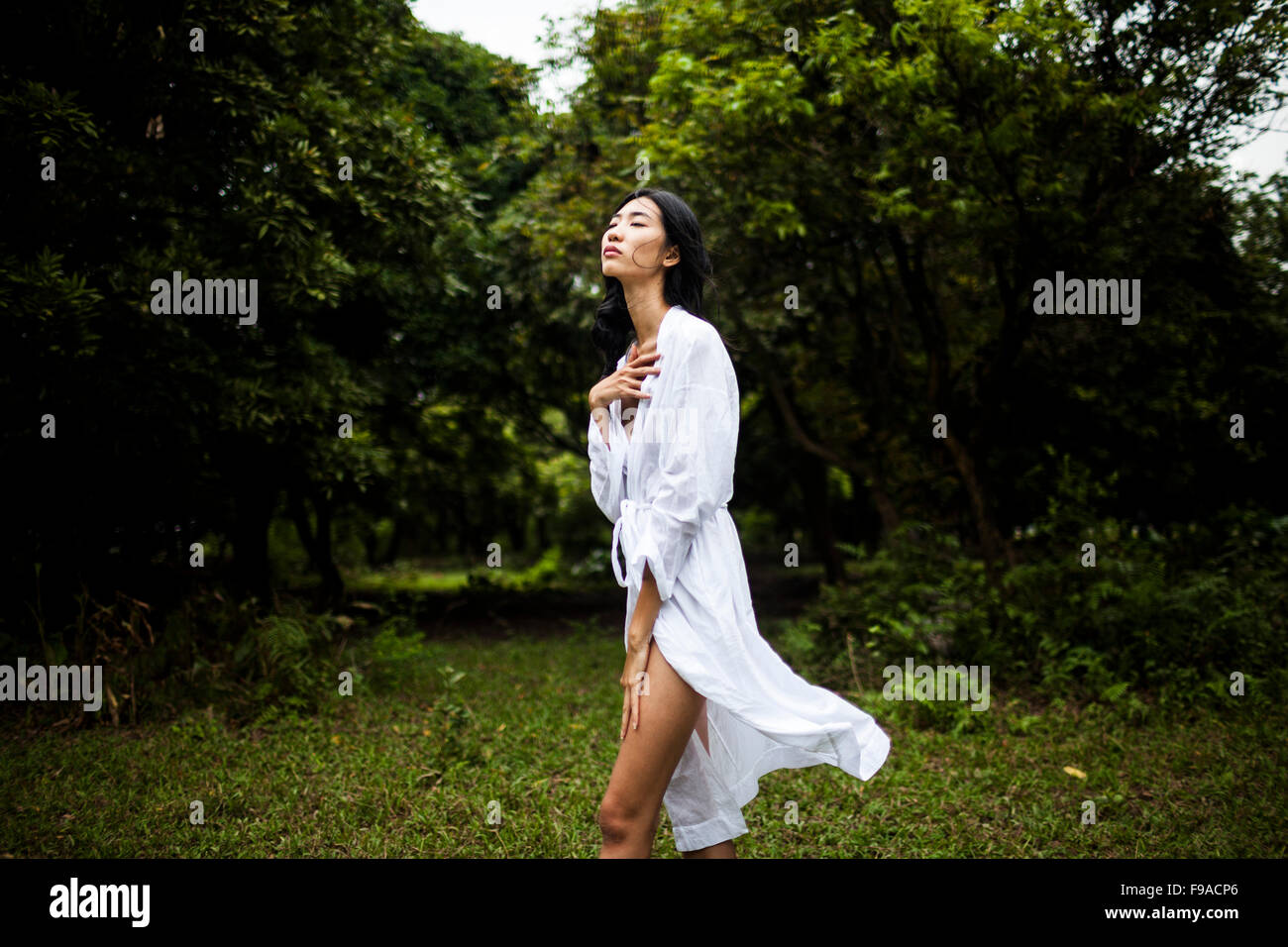 Une jeune vietnamienne portant tous les vêtements blancs au milieu d'un champ vert dans les régions rurales de Hanoi, Vietnam. Banque D'Images