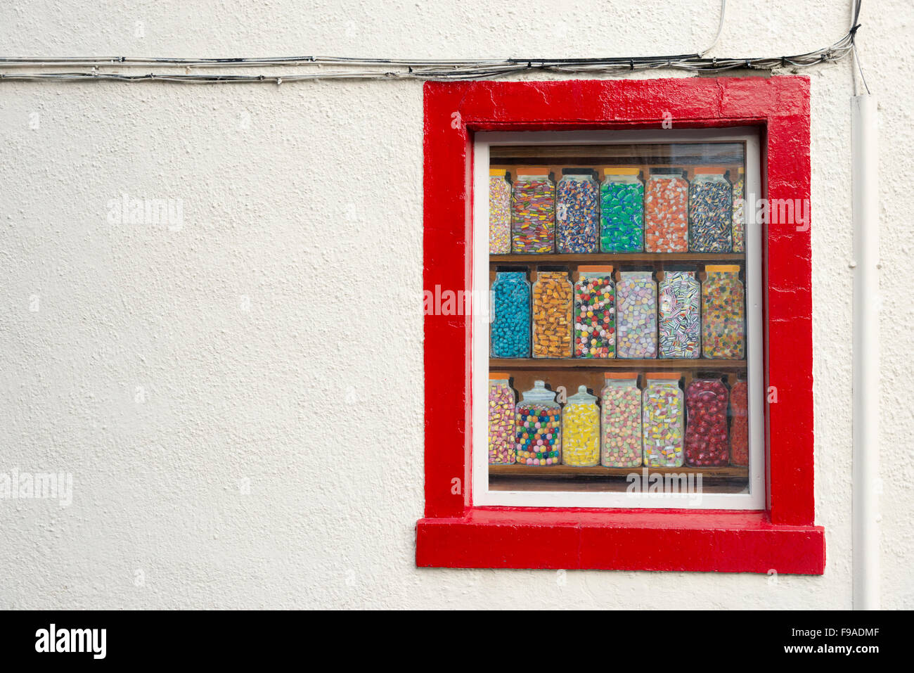L'art de mur sur le côté d'un immeuble à Penrith Cumbria UK. Une peinture de pots de bonbons dans une fenêtre d'un sweet shop. Banque D'Images