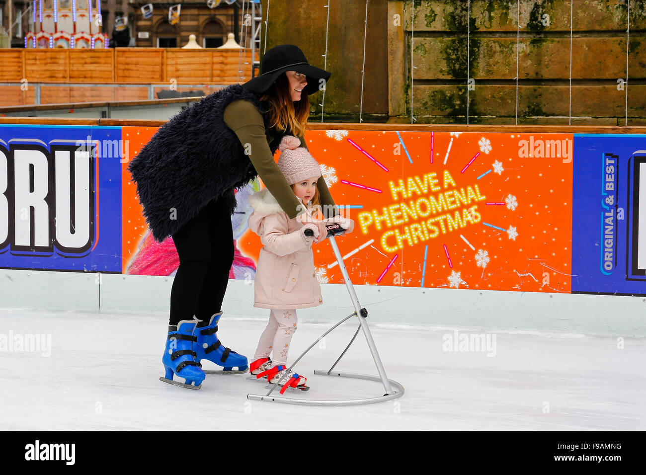 Glasgow, Ecosse, Royaume-Uni. Le 15 décembre, 2015. Glasgow des Christmas on Ice' superbe piscine patinoire de George Square dans le centre-ville attire des patineurs de tous âges et de toutes capacités. Ceux qui sont un peu instable sur la glace obtenez un un peu d'aide de parents et de leurs proches. Un moyen amusant d'avoir une pause de shopping de Noël. Credit : Findlay/Alamy Live News Banque D'Images