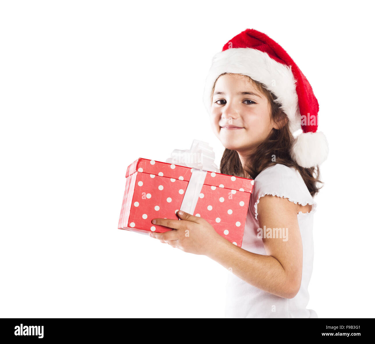 Petite fille heureuse à santa hat with christmas gift Banque D'Images