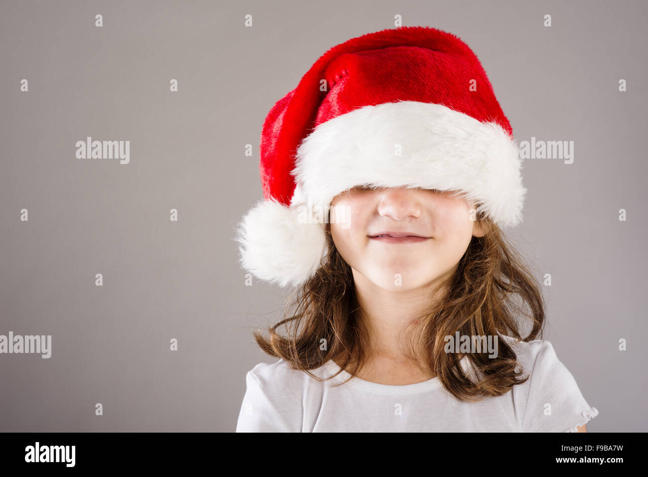 Petite fille heureuse en grande santa hat Banque D'Images