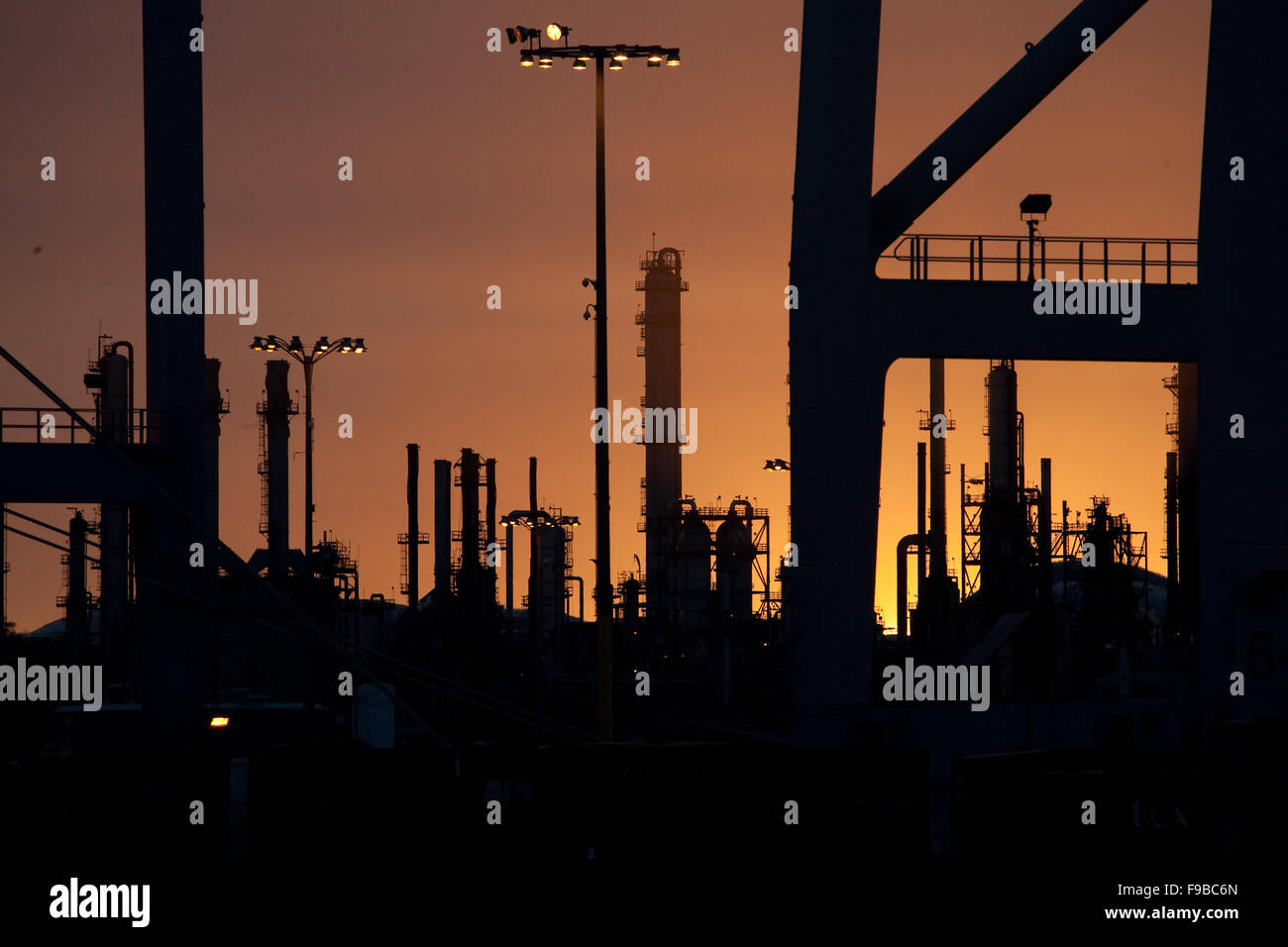 Raffinerie de pétrole comme vu par un conteneur roulant au coucher du soleil Banque D'Images