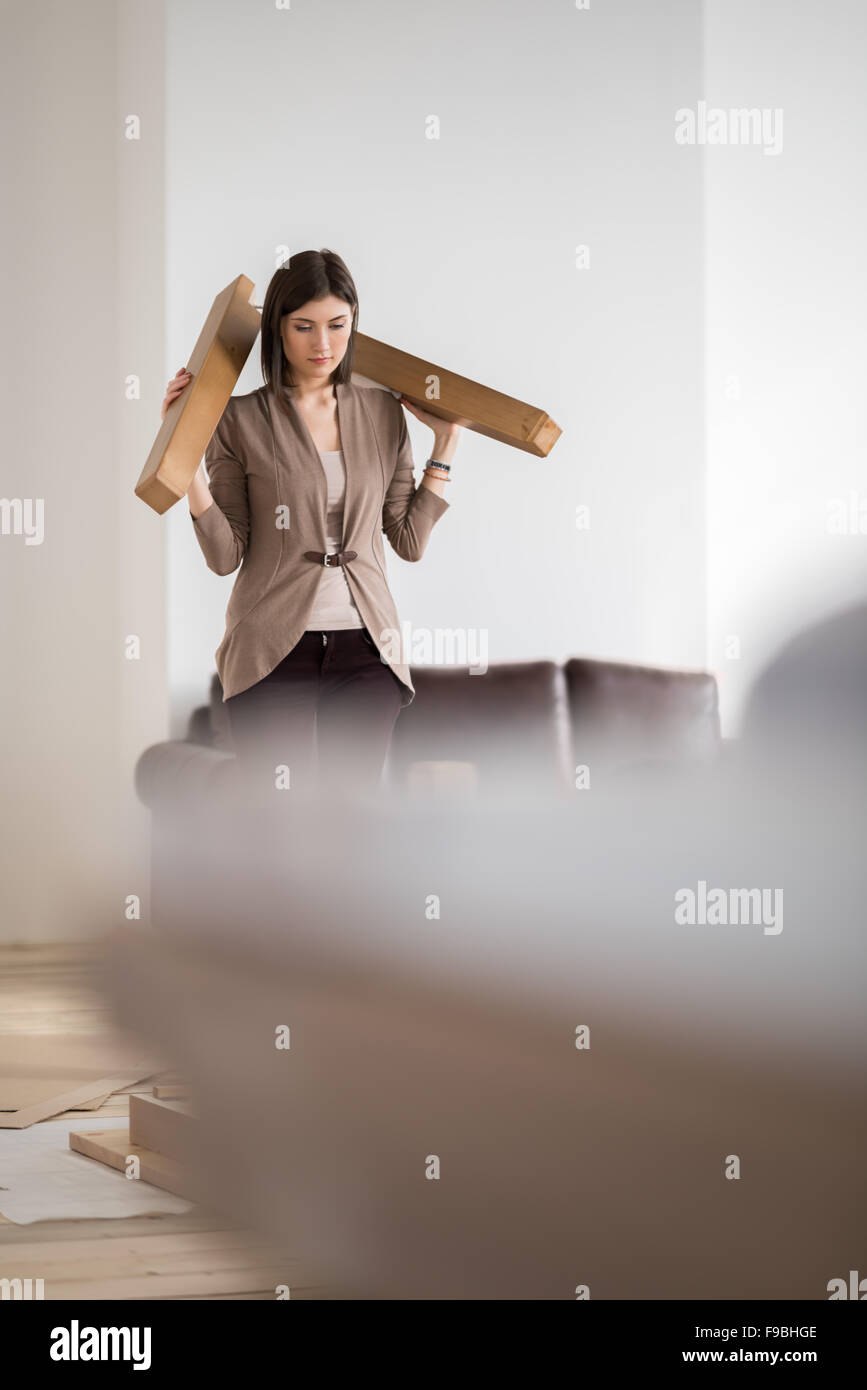 Jeune femme faisant des réparations bricolage à la maison mettre ensemble de meubles à assembler soi-même Banque D'Images