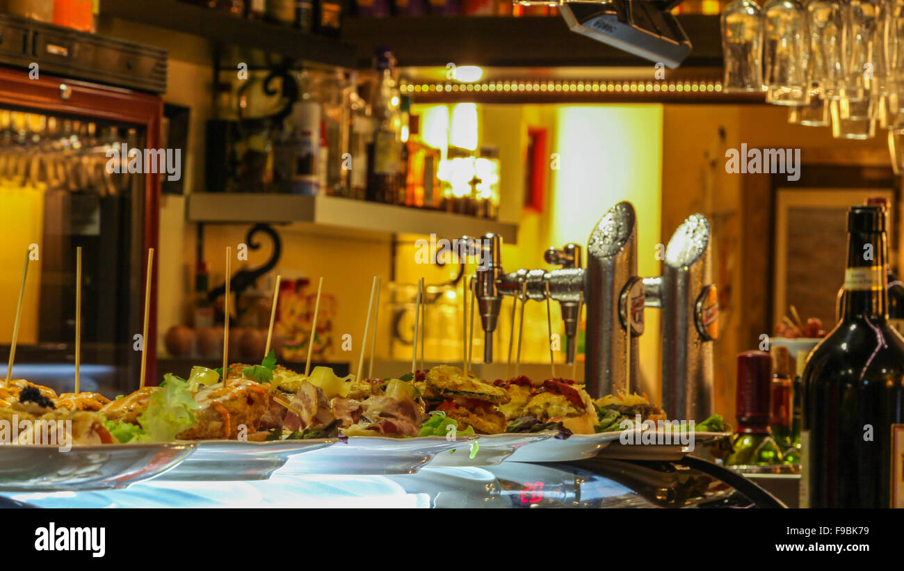 Table supérieure en bar à tapas espagnol avec sélection de pompes à bière, des aliments et des verres, Close up. Banque D'Images