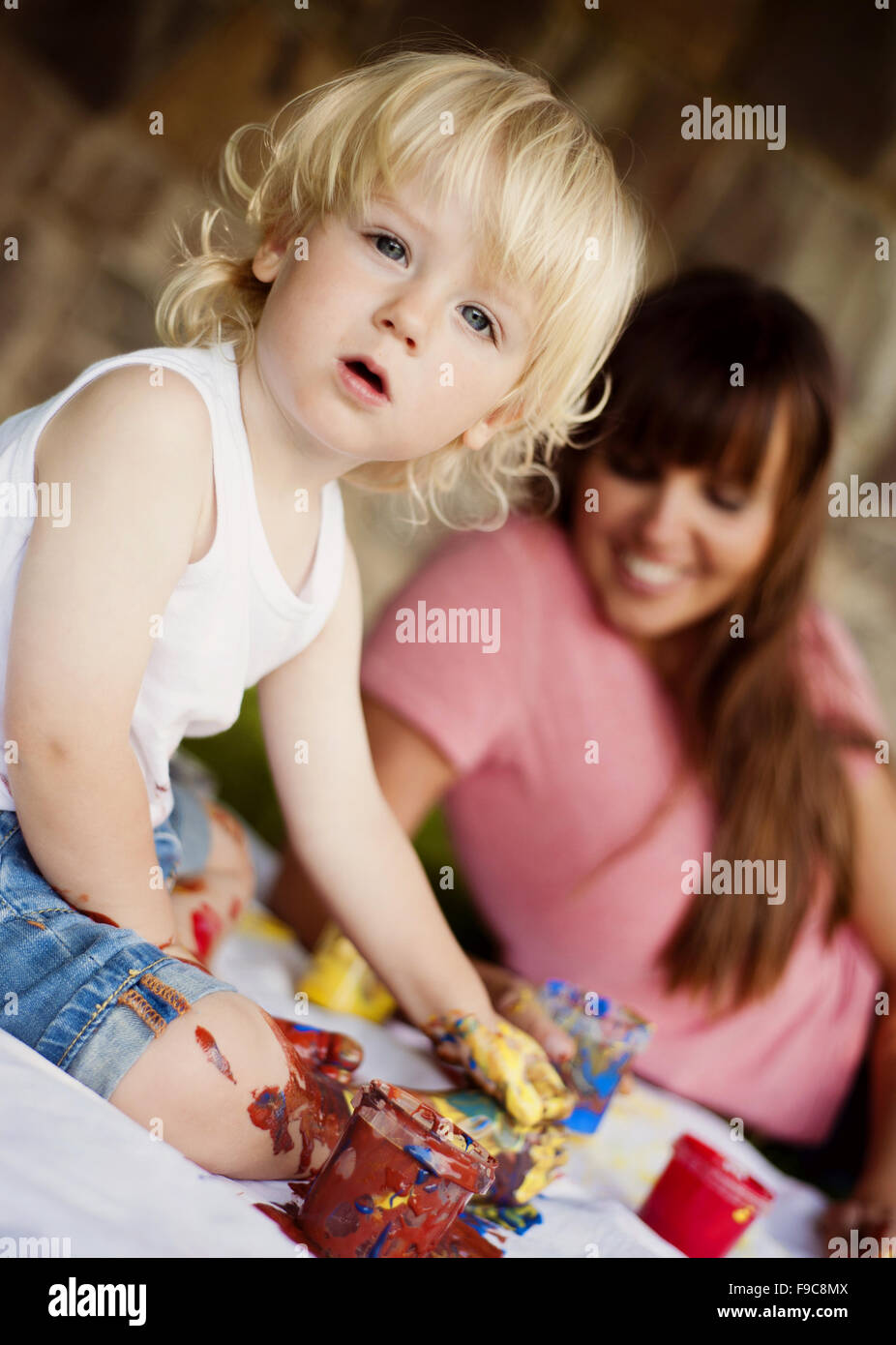 Peinture enfant mignon avec des couleurs vibrantes dans le jardin Banque D'Images