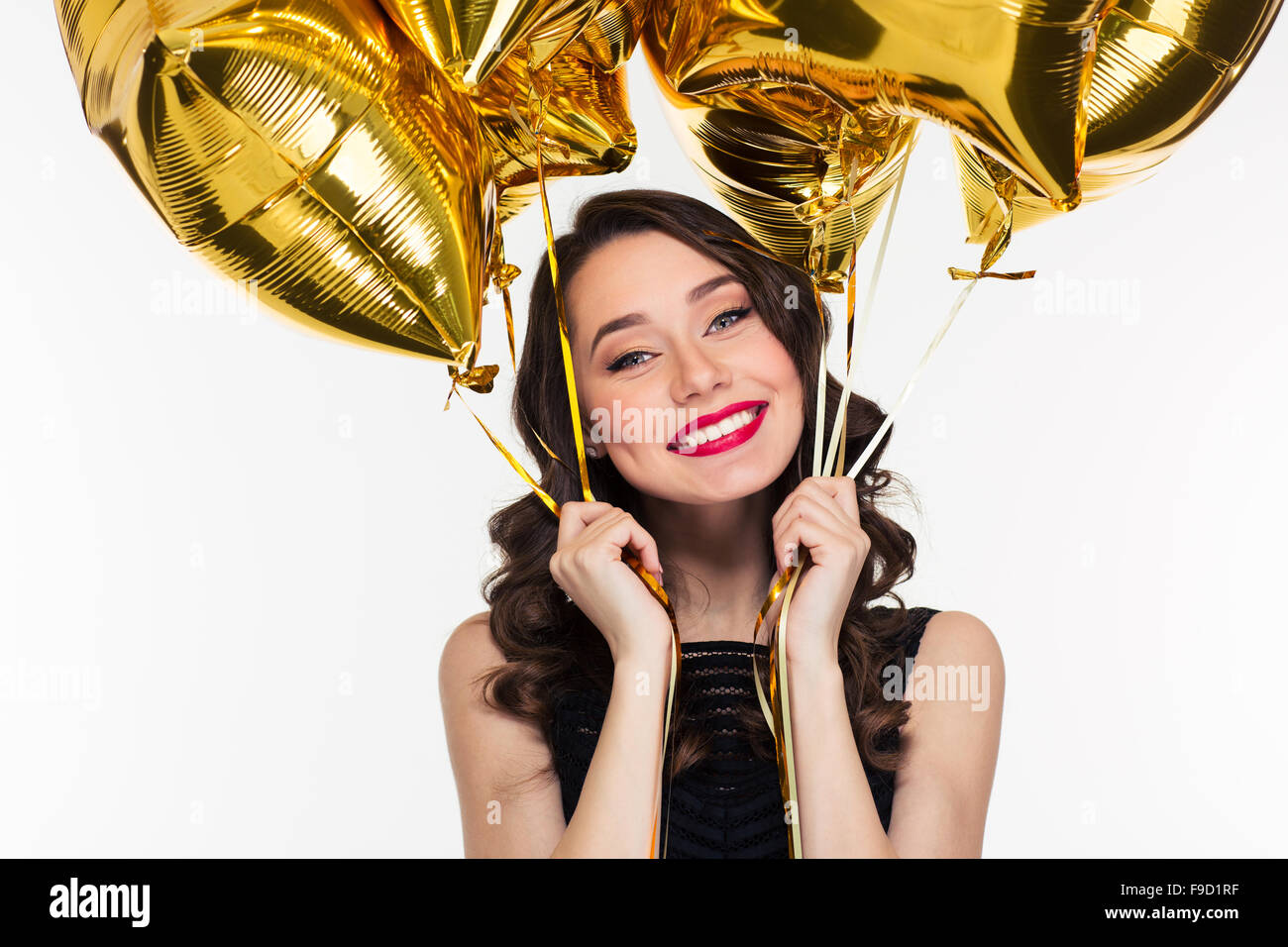 Happy happy belle jeune femme style rétro en tenant des ballons d'or sur fond blanc Banque D'Images
