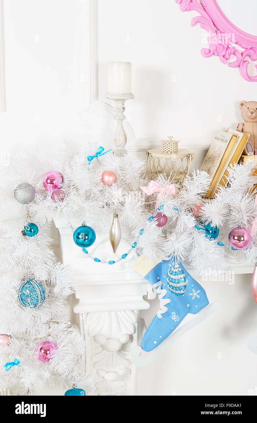 Guirlande blanche au-dessus de la cheminée avec patins bleu et des jouets Banque D'Images