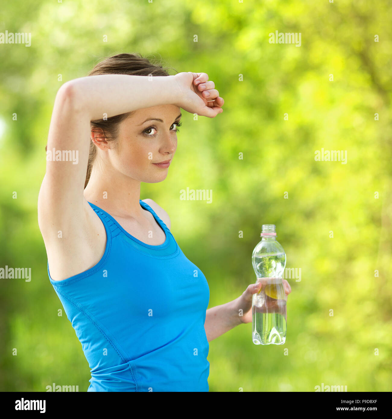 L'actualisation de l'athlète avec une bouteille d'eau au cours de l'exercice en plein air Banque D'Images