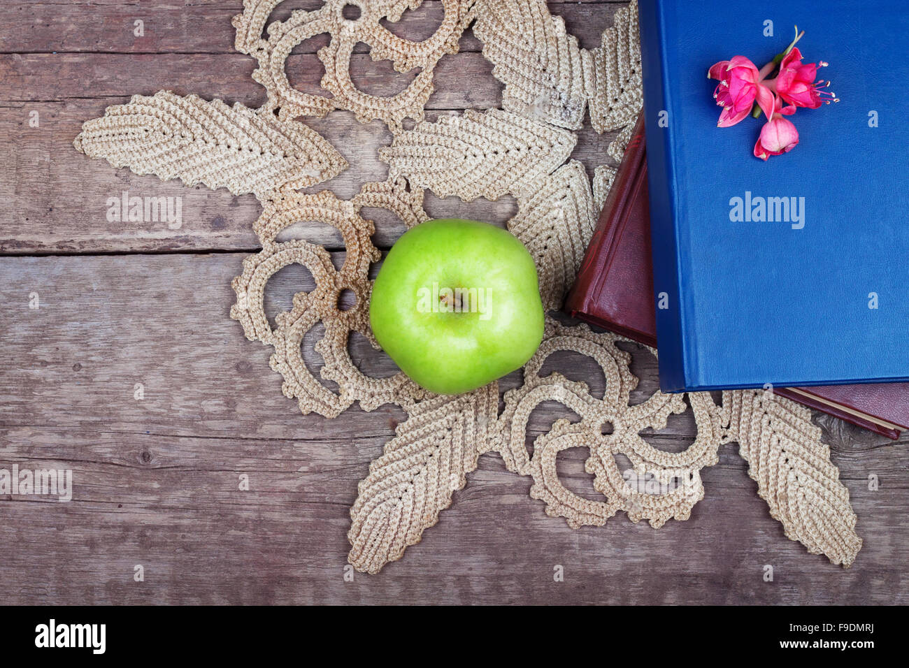 Pile de livres et de pomme verte sur table en bois vintage Banque D'Images