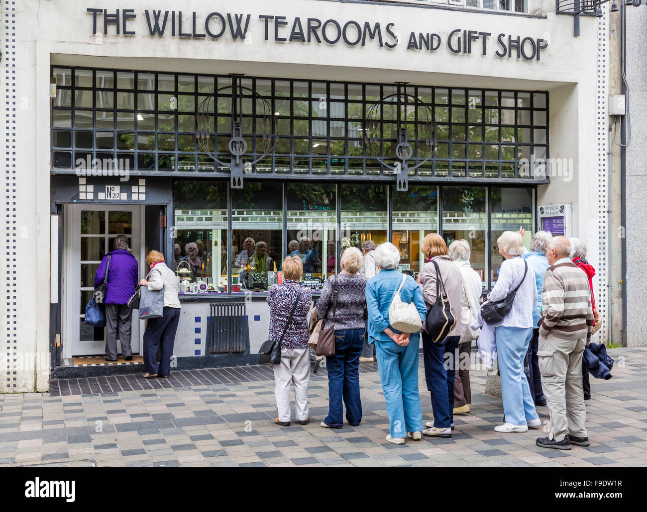 Un groupe de touristes à l'extérieur de Willow Tearooms et l'ancienne boutique de cadeaux sur Sauchiehall Street dans le centre-ville de Glasgow, en Écosse, au Royaume-Uni Banque D'Images