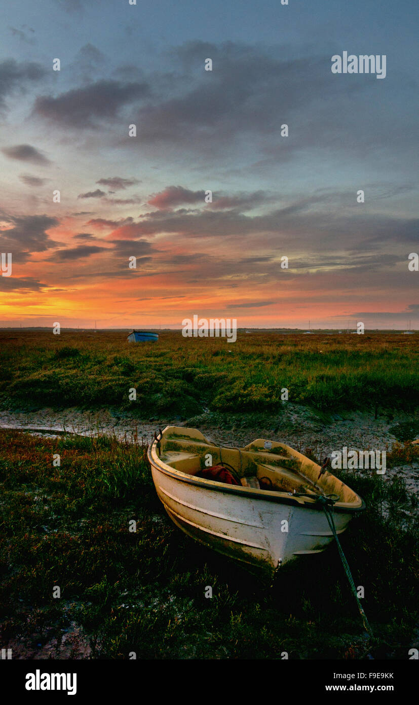 Coucher de soleil sur les bateaux et les marais à Brancaster Staithe , Norfolk, Angleterre Banque D'Images