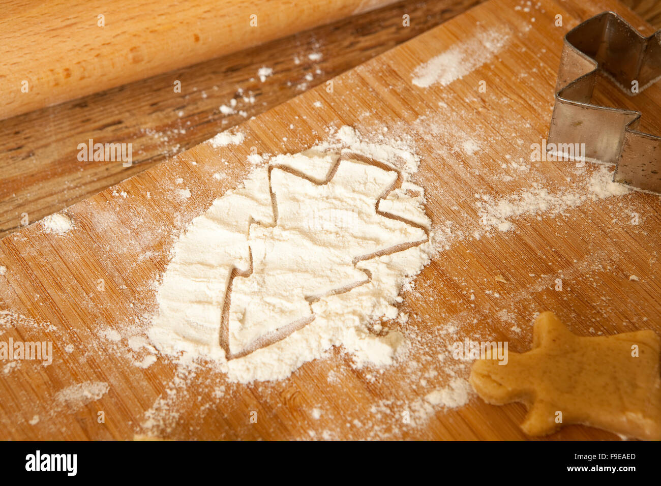 Les plaisirs de l'hiver. Les épices est tout coupé pour une forme de coupe est utilisé pour constituer un modèle dans un petit tas de farine. Banque D'Images
