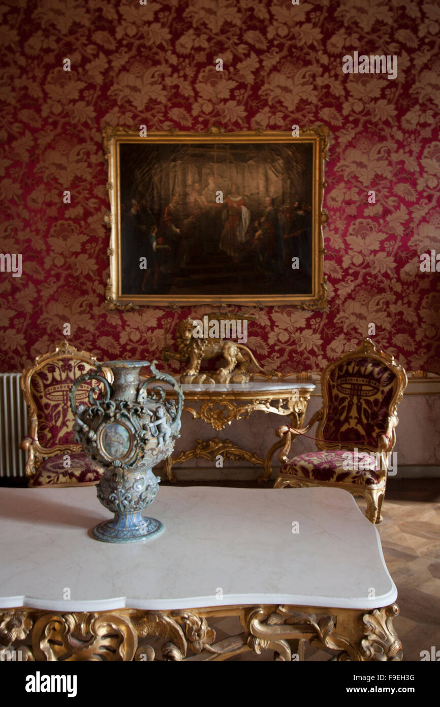 Chambre rouge et or avec des tables en marbre et des chaises Banque D'Images
