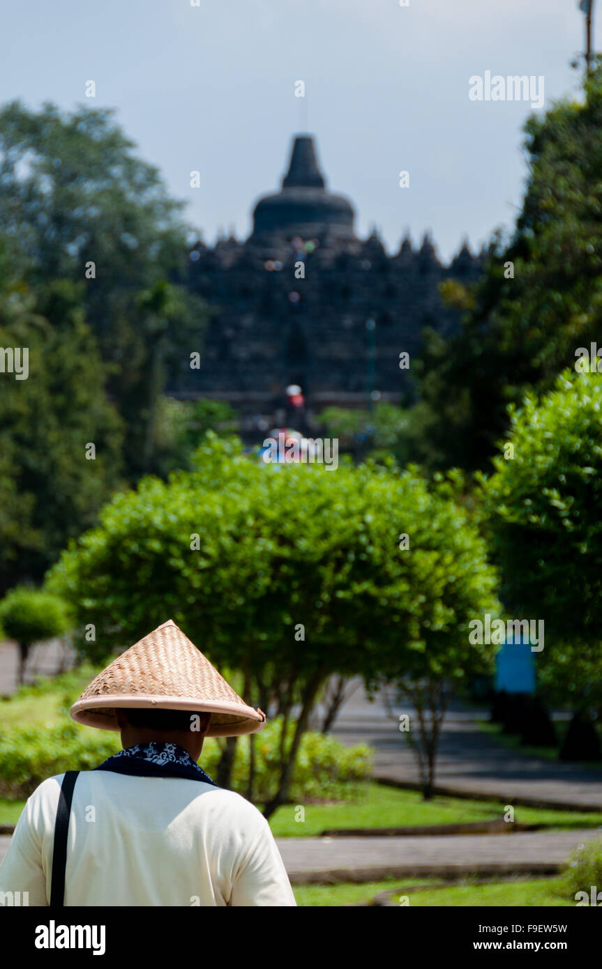 Homme avec chapeau de paille à marcher en direction de Borobudur temple Banque D'Images