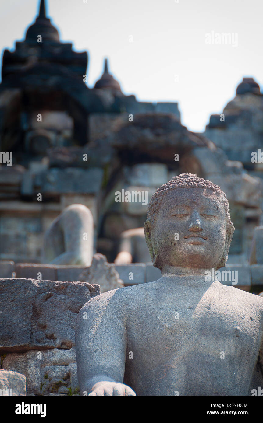 Assis et Bouddha souriant dans la pierre à Borobudur Banque D'Images