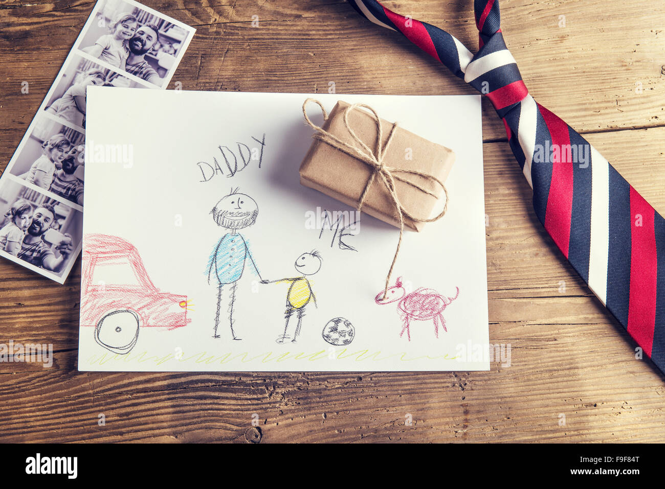 Photos Polaroid de père et fille, dessin d'enfant, du présent et de l'égalité mis sur fond d'un bureau en bois. Banque D'Images