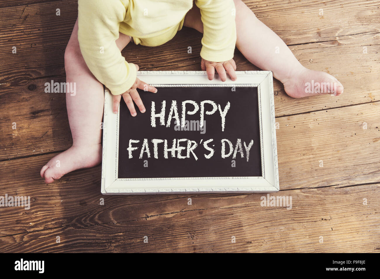Petit bébé avec Happy fathers day sign sur fond de bois Banque D'Images