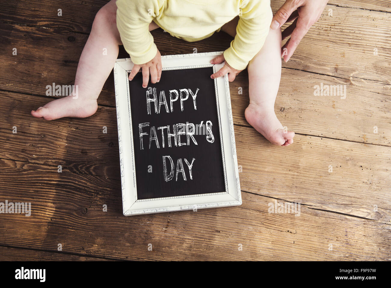 Petit bébé avec Happy fathers day sign sur fond de bois Banque D'Images