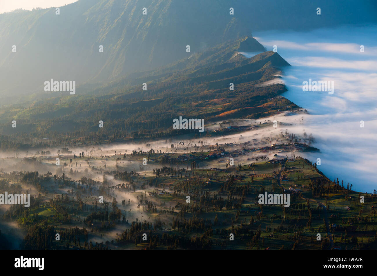 Couche de brume sur les montagnes et dans un village Banque D'Images