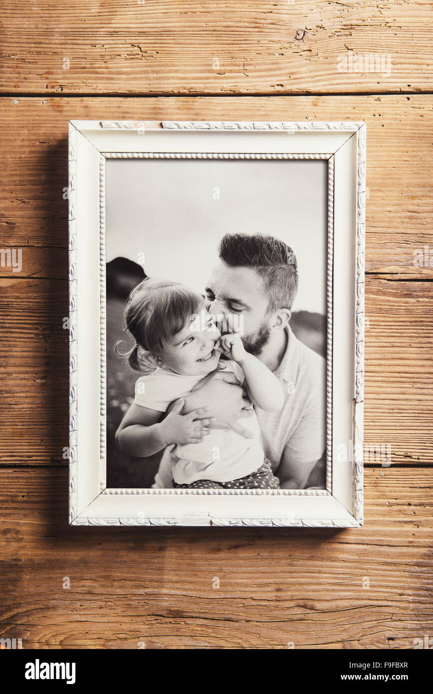 Photo de famille en blanc cadre photo. Studio shot sur fond en bois. Banque D'Images