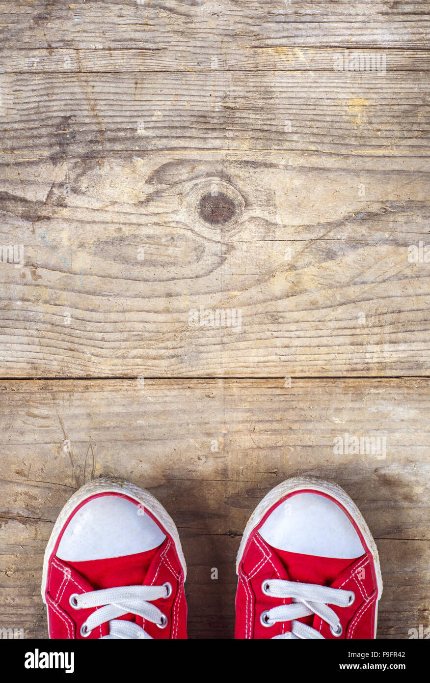 Concept avec red sneakers posés sur plancher en bois. Banque D'Images