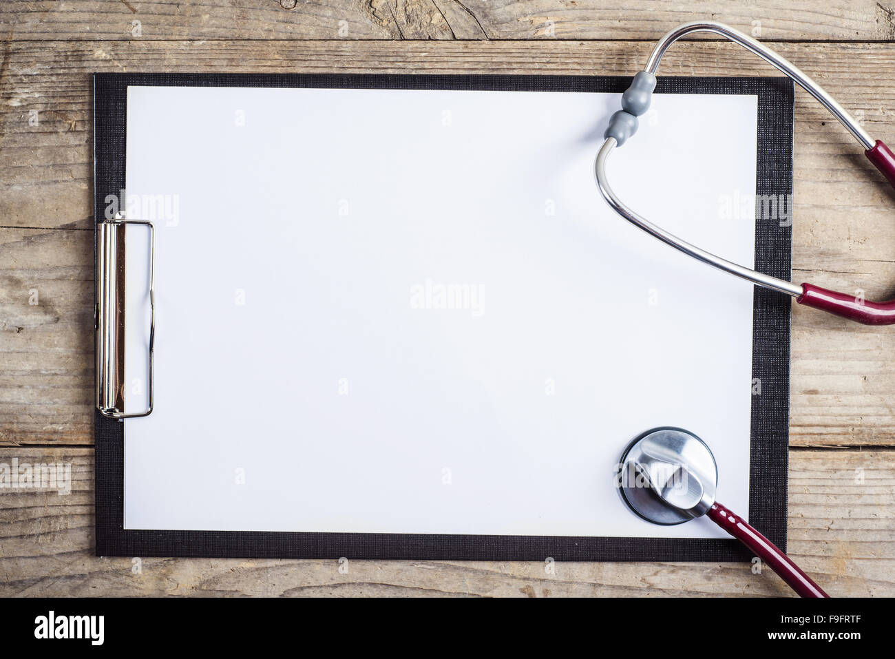 Poste de travail d'un médecin. Stéthoscope et papiers sur fond d'un bureau en bois. Banque D'Images