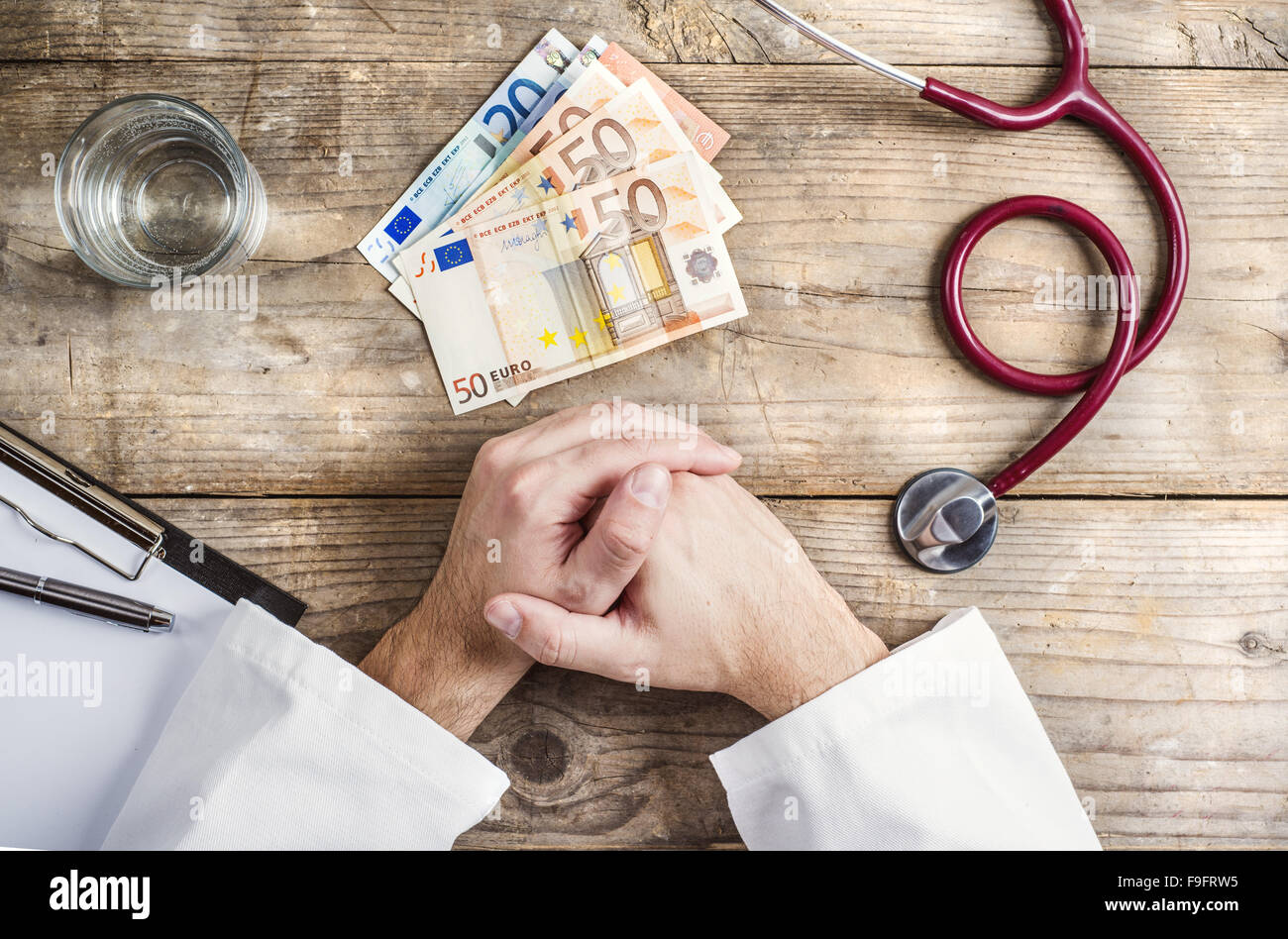 Mains d'accepter un pot-de-médecin méconnaissable. Fond d'un bureau en bois. Banque D'Images