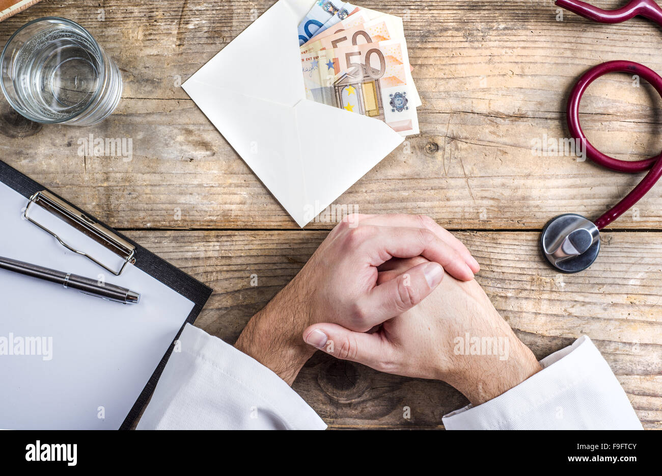 Mains d'accepter un pot-de-médecin méconnaissable. Fond d'un bureau en bois. Banque D'Images