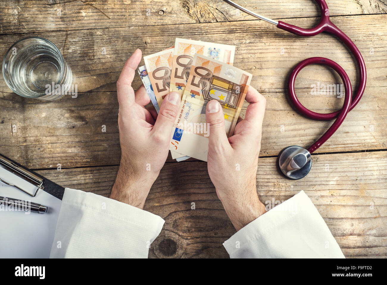 Mains d'accepter un pot-de-médecin méconnaissable. Fond d'un bureau en bois. Banque D'Images