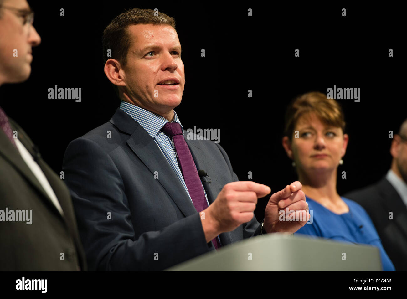 UK politics : RHUN AP IORWERTH , membre du Plaid Cymru le 'shadow cabinet' sur la plate-forme à la Conférence annuelle 2015 du parti à Aberystwyth, Pays de Galles, Royaume-Uni observé par le chef du parti LEANNE BOIS Banque D'Images