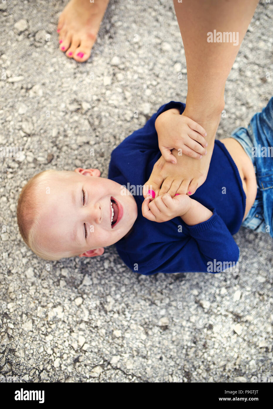 Petit garçon allongé sur le sol à jouer avec cette mère Banque D'Images