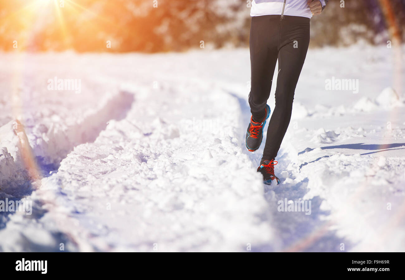 Les jambes de jeunes sportifs du jogging en extérieur dans un parc d'hiver Banque D'Images