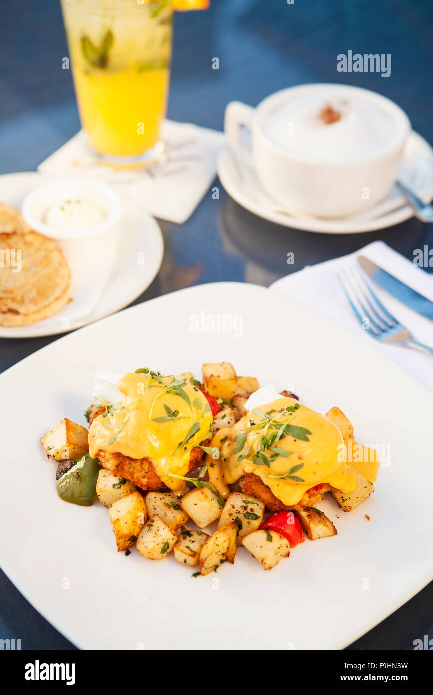 Œufs pochés et de gâteaux de crabe dormeur sur le petit déjeuner pommes de terre, le chipotle sauce hollandaise, avocat et pico de gallo Banque D'Images
