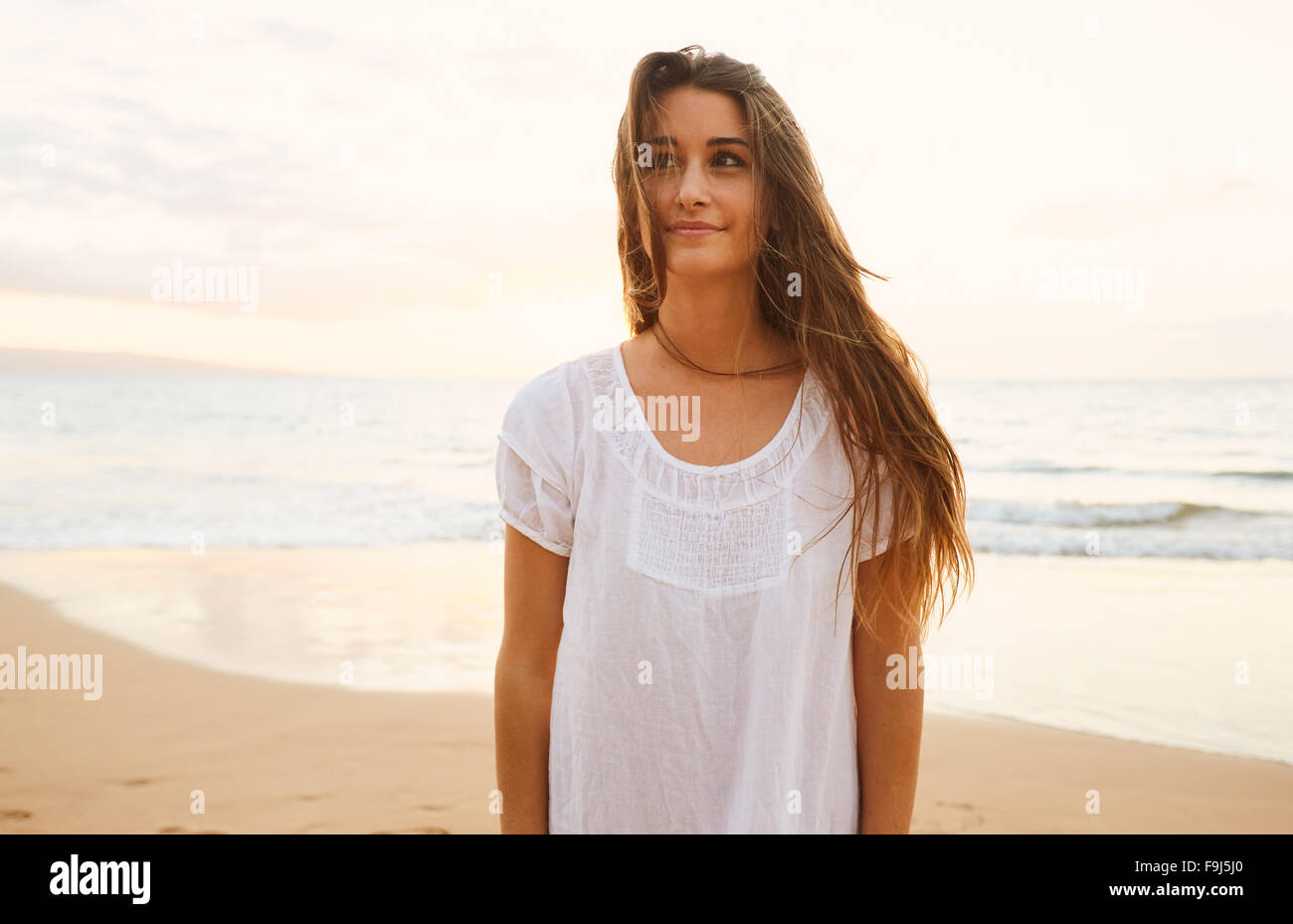 Happy Carefree Woman magnifique coucher de soleil sur la plage Banque D'Images