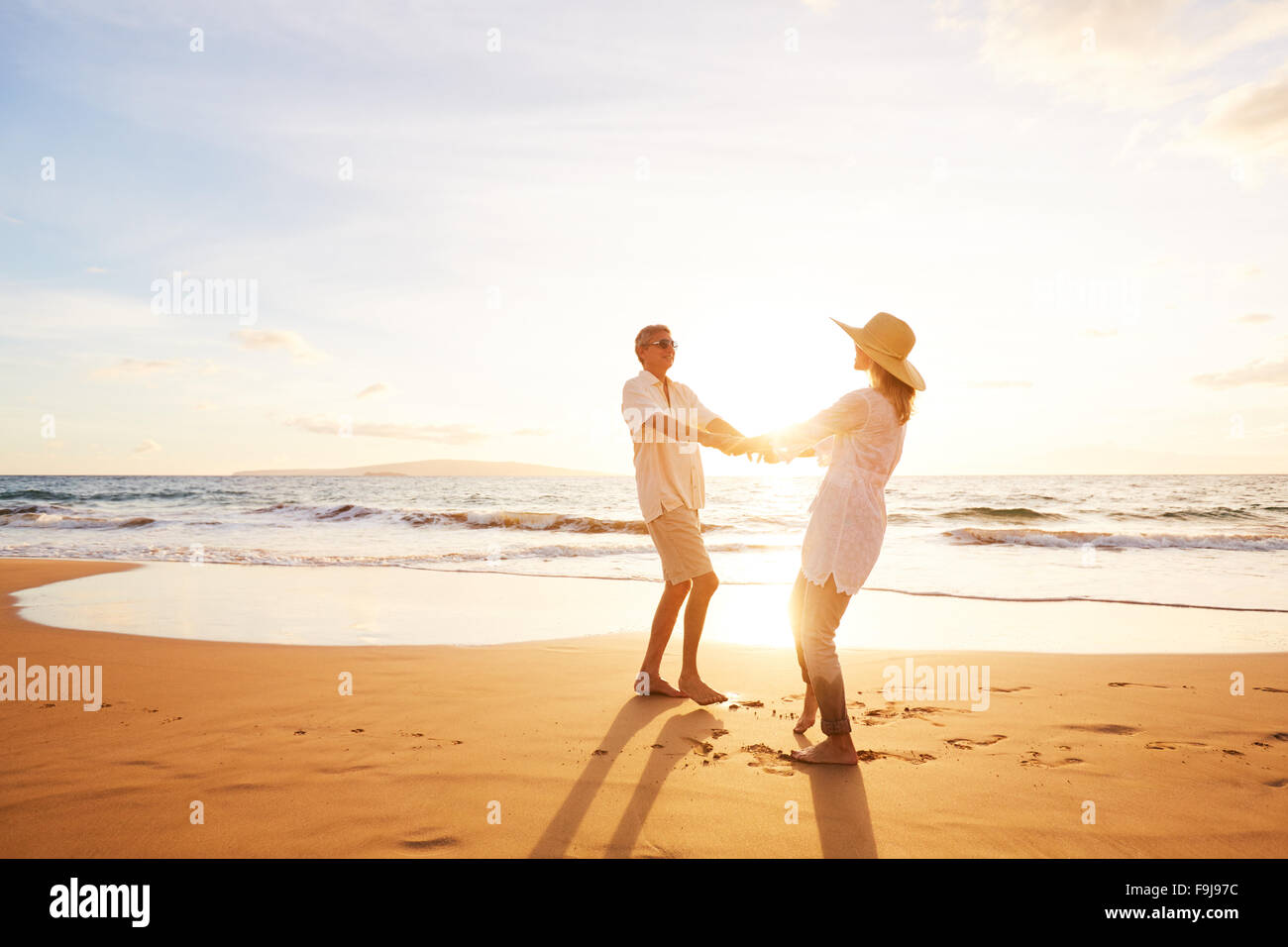 Happy Romantic Couple Enjoying magnifique coucher de soleil sur la plage. Voyage Vacances Retraite de concept. Banque D'Images