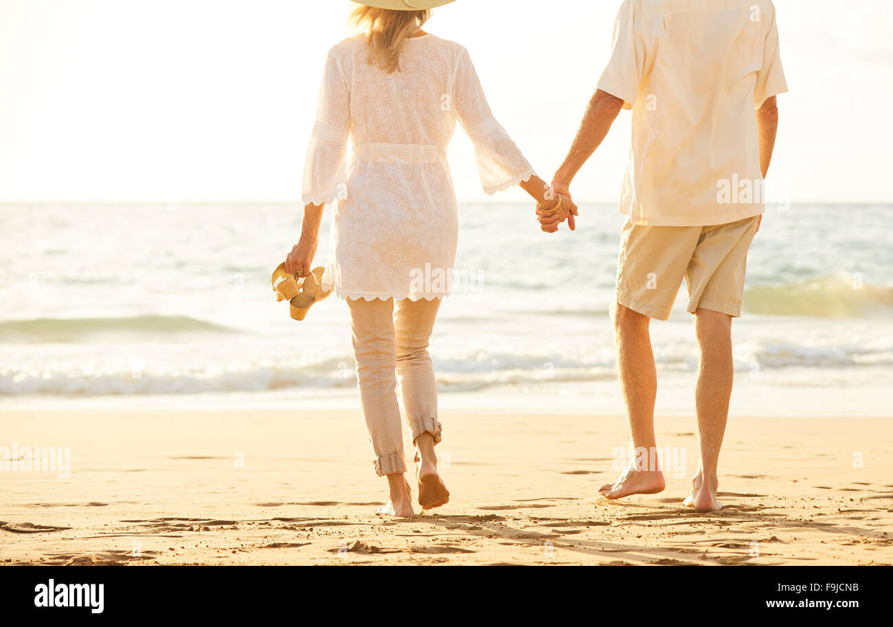 Happy Romantic Couple d'âge moyen avec sa promenade sur la plage au coucher du soleil. Voyage Vacances Concept de vie à la retraite Banque D'Images