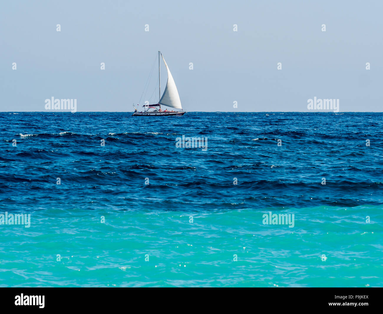 Yacht avec voiles blanches aller à pleine vapeur sur la surface de la mer d'azur Banque D'Images