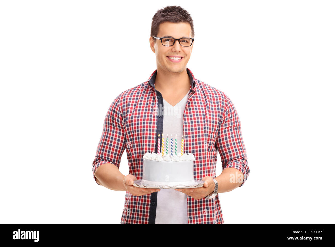 Cheerful young guy tenant un gâteau d'anniversaire et regardant la caméra isolé sur fond blanc Banque D'Images