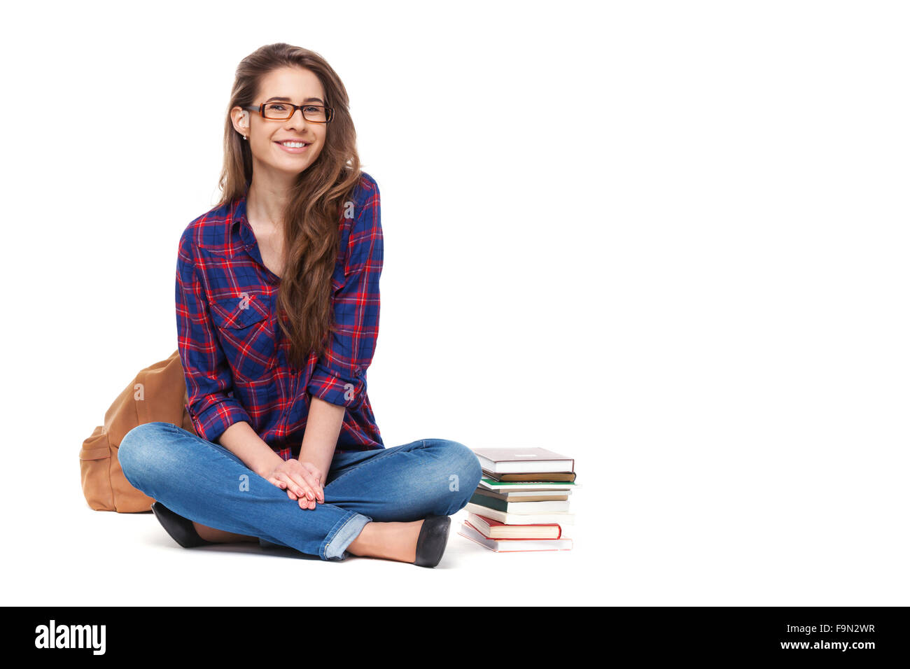 Portrait of happy female student sitting isolé sur blanc. Banque D'Images
